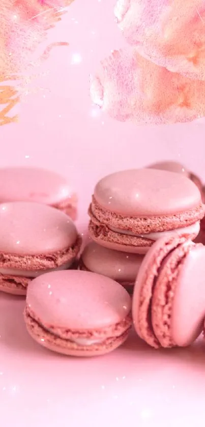 Pink macarons with floral accents on a wallpaper.