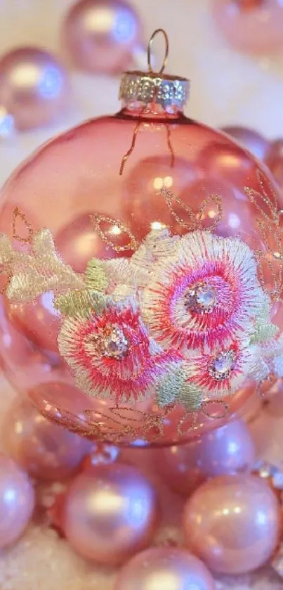 Elegant pink Christmas ornament with floral design on a mobile wallpaper.