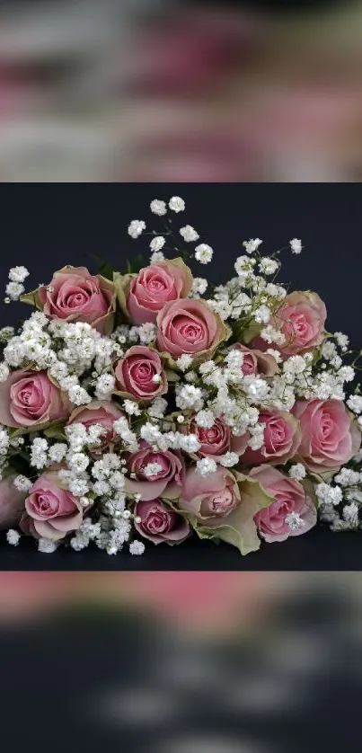 Bouquet of pink roses and white baby's breath on dark background.