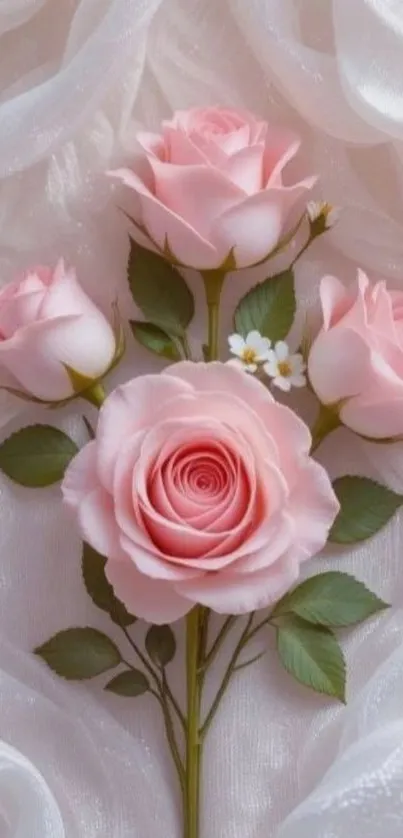 Elegant pink roses with green leaves on soft fabric background.
