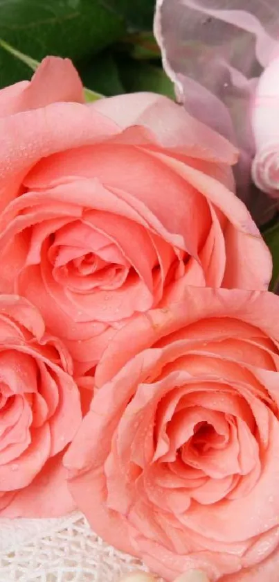 Elegant pink roses with pearls and green leaves in a serene floral arrangement.