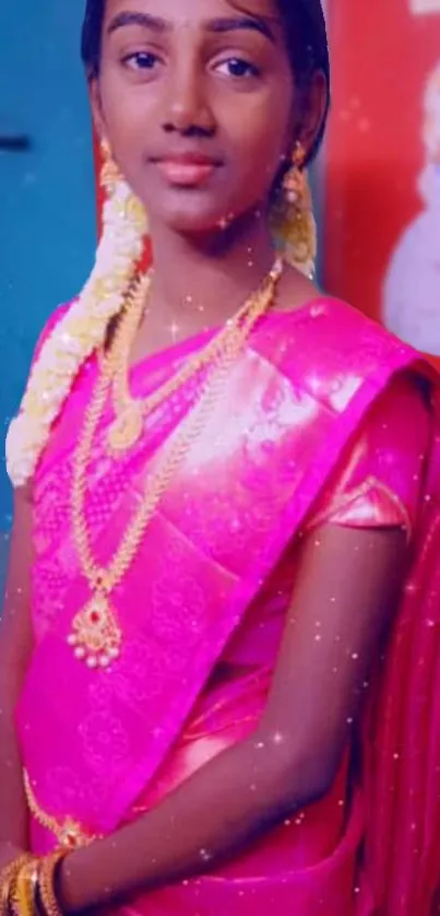 Woman in pink saree with gold jewelry, vibrant and elegant.