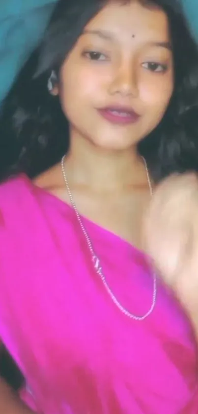 Woman in pink sari with elegant expression.