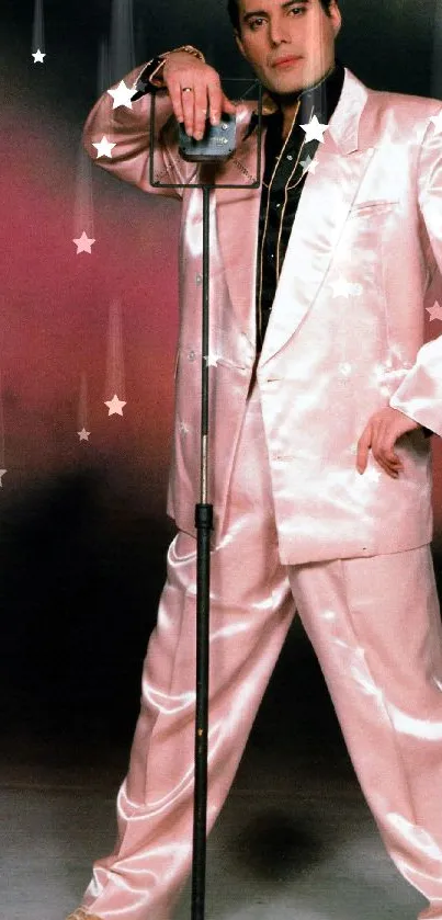 Individual in a pink satin suit leaning on a microphone stand, exuding elegance.