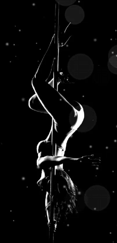 Captivating black and white silhouette of a pole dancer in an elegant pose.