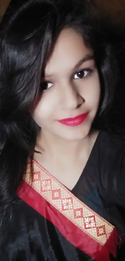 Elegant woman in black saree with red lips posing gracefully.