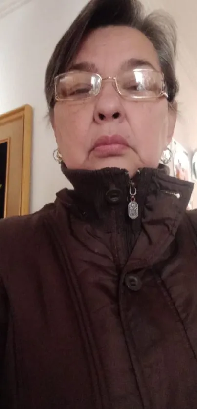 Portrait of a woman wearing a brown jacket in an indoor setting.