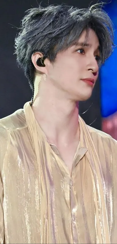 Fashionable individual in golden attire, with a modern hairstyle and a serene expression.