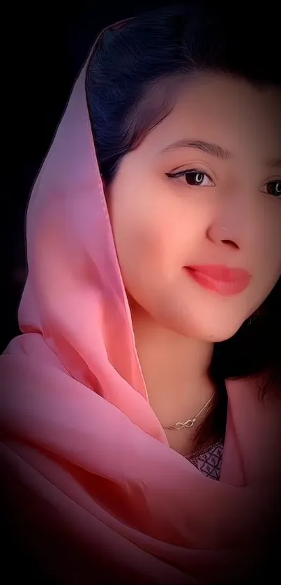 Serene portrait of a woman in a pink hijab on a black background.