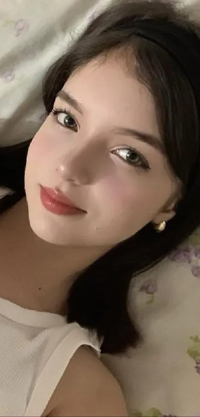 Portrait of a woman with serene expression on mobile wallpaper.