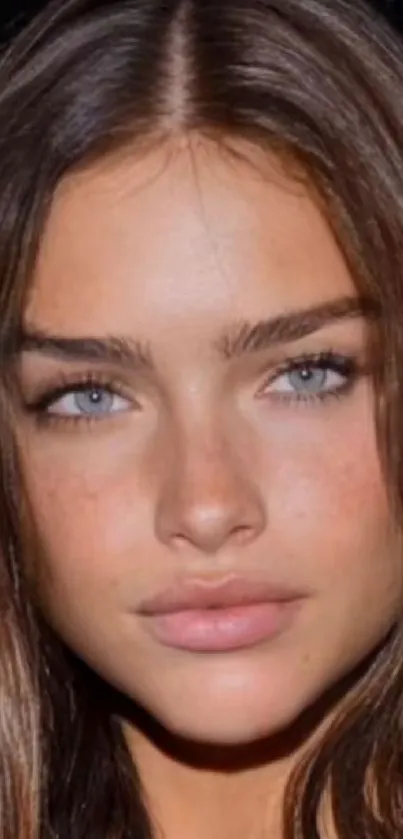 Close-up portrait of a person with striking blue eyes and brown hair.