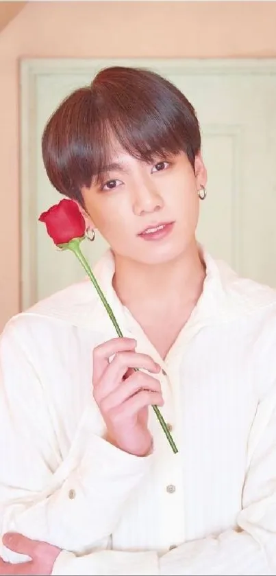 A young person holding a red rose with a pastel background.