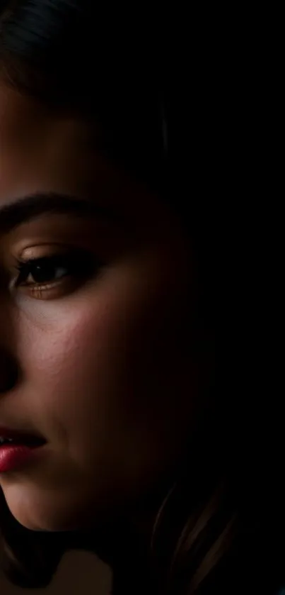 Profile portrait of a serene young woman against a dark backdrop, perfect for mobile.