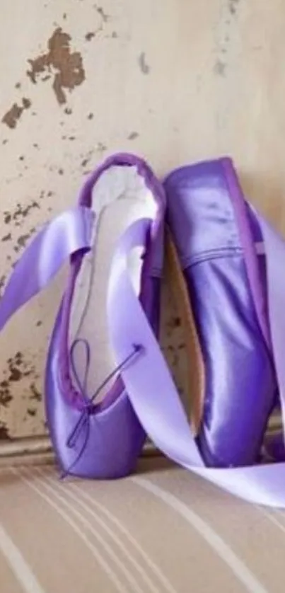 Purple ballet shoes with ribbons against a rustic backdrop.