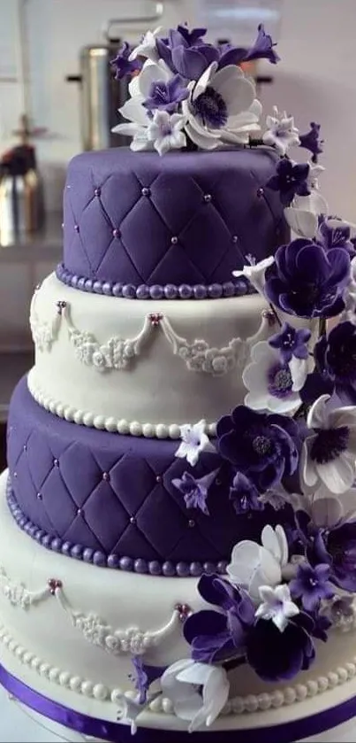 Purple and white wedding cake with flower decorations.