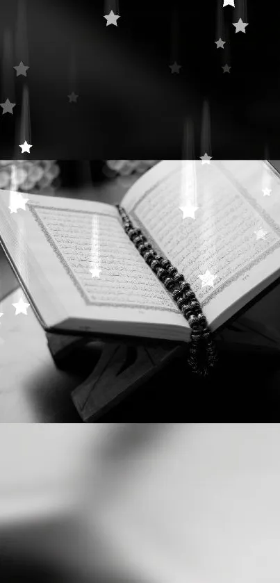 Black and white wallpaper of an open Quran with rosary and starry backdrop.