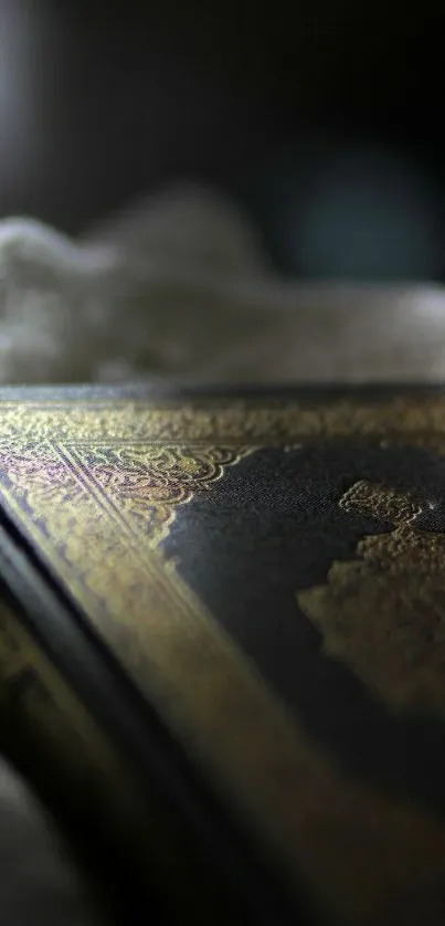 Close-up of a Quran with gold detailing on a dark, textured surface.