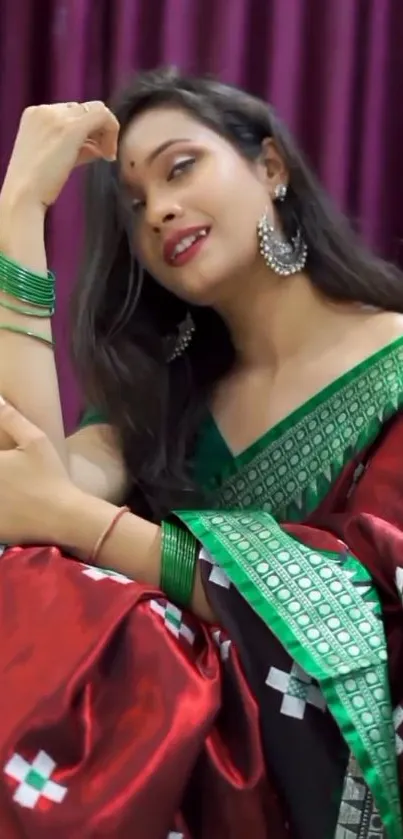 Woman in elegant red and green saree with accessories.