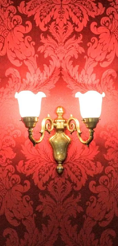 Red damask wallpaper with a vintage wall sconce illuminated.