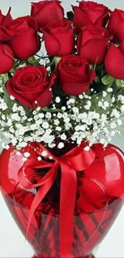 Bouquet of red roses in a glass vase with a red ribbon, on a light background.