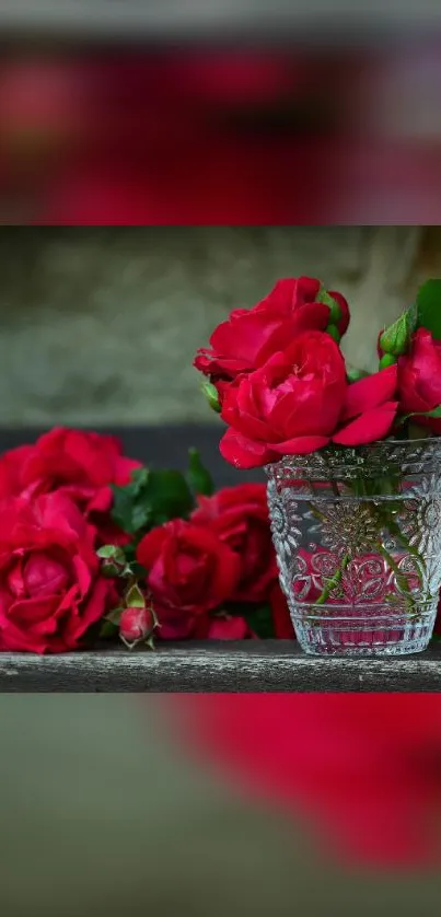 Red roses beautifully arranged in a glass vase against a soft background.