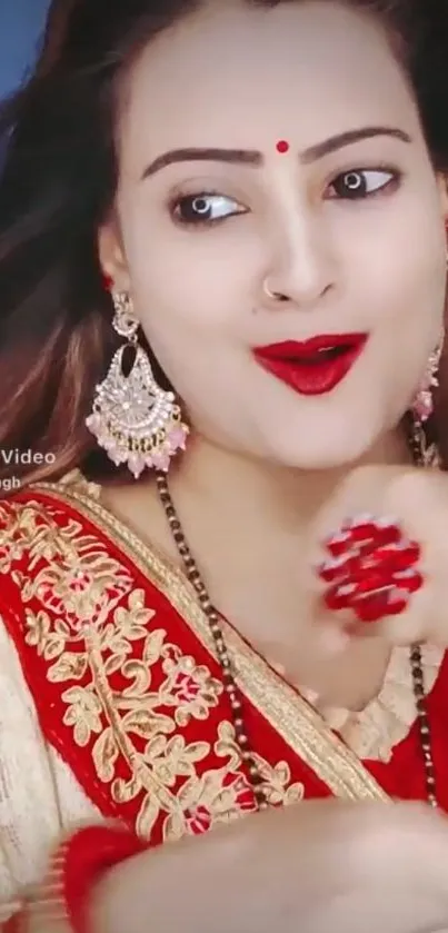 Woman in red saree with elegant earrings.