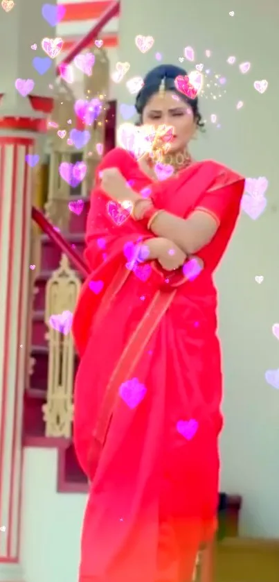 Woman in red saree with floating hearts on mobile wallpaper.