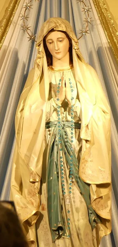 Elegant religious statue with golden and blue drapery, highlighting peace and spirituality.