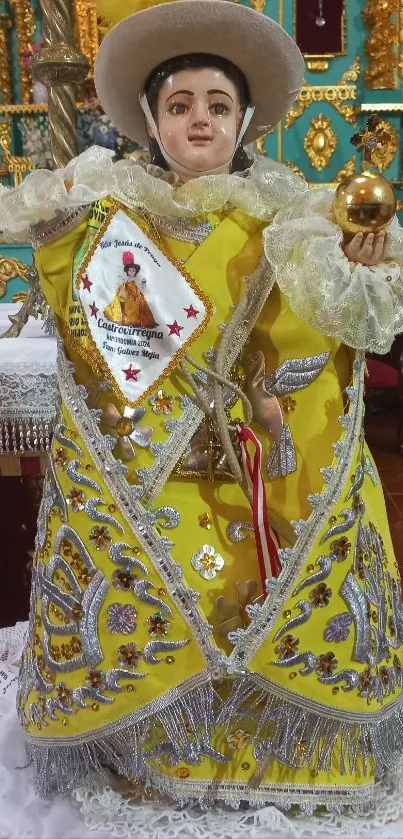 Intricate religious figurine in vibrant yellow attire as a mobile wallpaper.