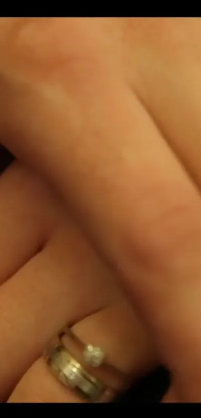 Close-up of hands with elegant rings in warm tones.