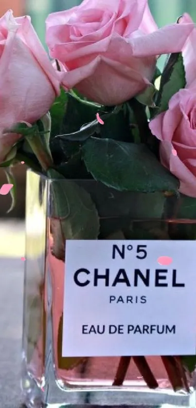 Mobile wallpaper with pink roses in a Chanel No. 5 perfume bottle.