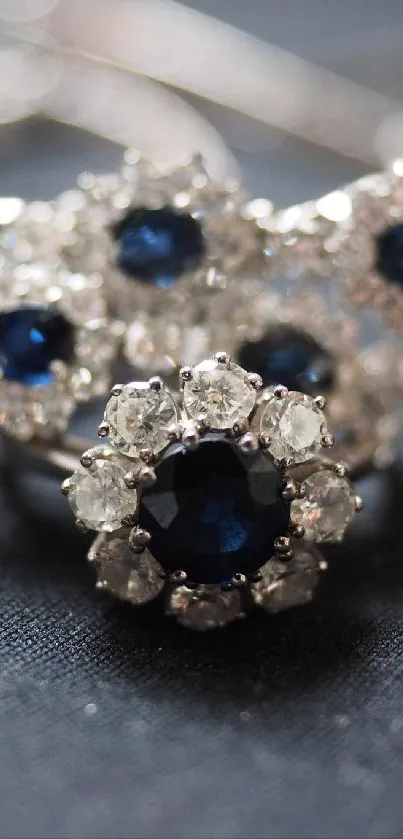 Close-up of sapphire and diamond jewelry on dark fabric.