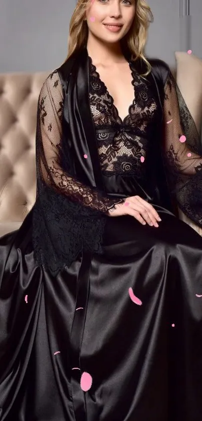 Elegant woman in a black satin and lace gown with pink accents.