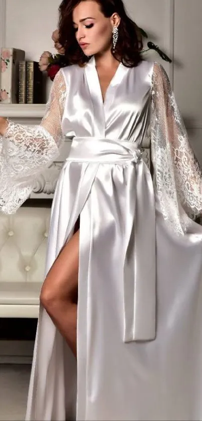 Woman in elegant satin robe with lace sleeves in a luxurious setting.