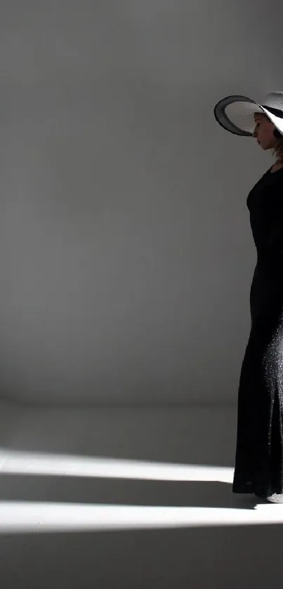 Silhouetted woman in black dress with shadows cast on a white background.