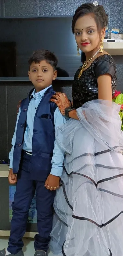 Elegant portrait of siblings in stylish attire indoors.