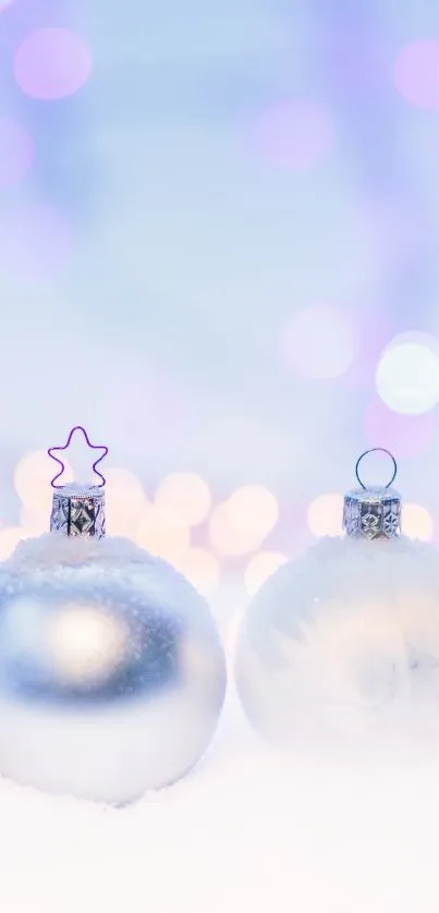 Silver Christmas ornaments in a snowy setting with bokeh lights.