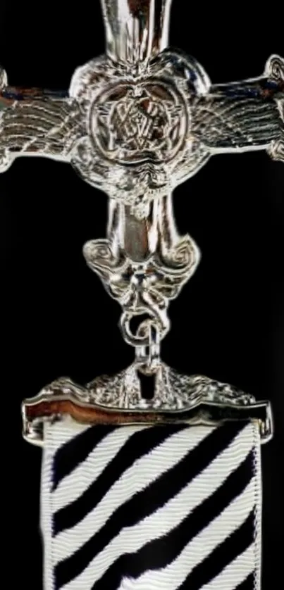 Intricate silver cross emblem with striped design background.