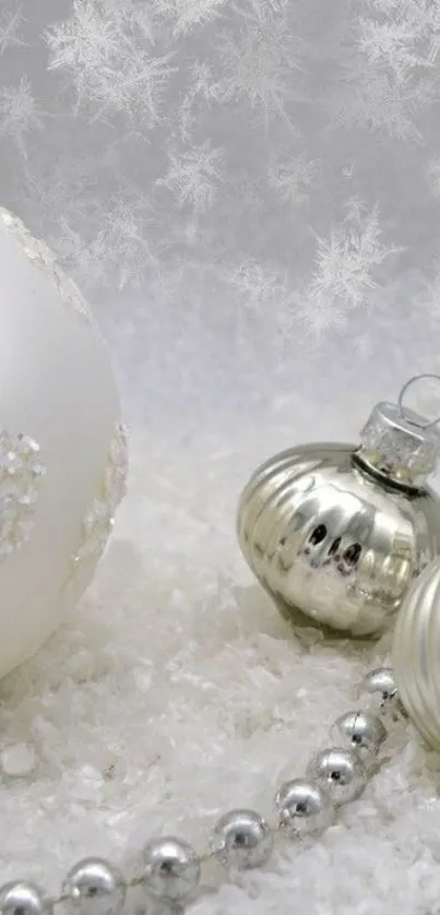 Silver Christmas ornaments on snow with elegant design.