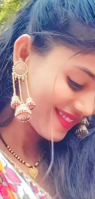 Smiling woman with earrings in a natural setting.