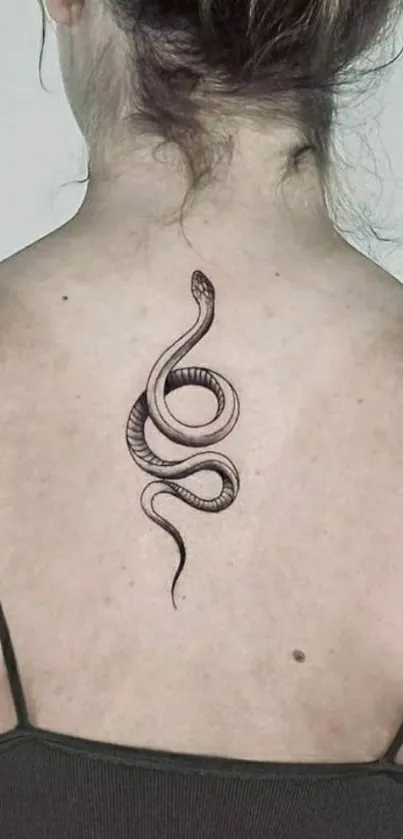 Elegant snake tattoo design on woman's back.