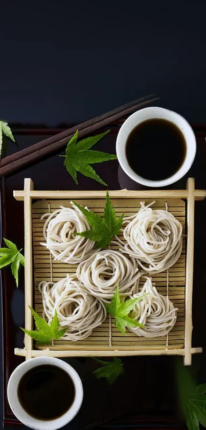 Soba noodles on bamboo mat with green leaves and chopsticks.