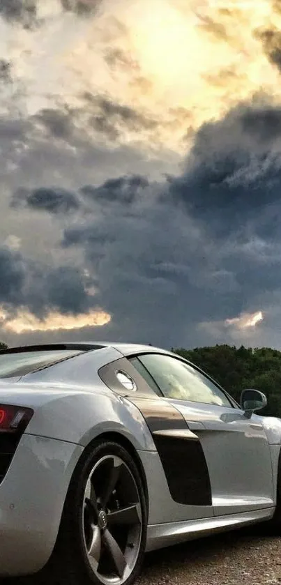 Sleek sports car beneath a cloudy sky, perfect for a stylish wallpaper.