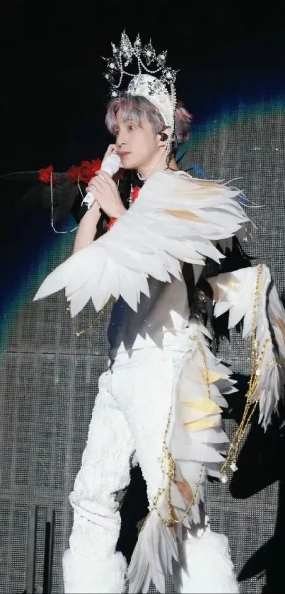 Person in dramatic feather outfit on stage with a crown.