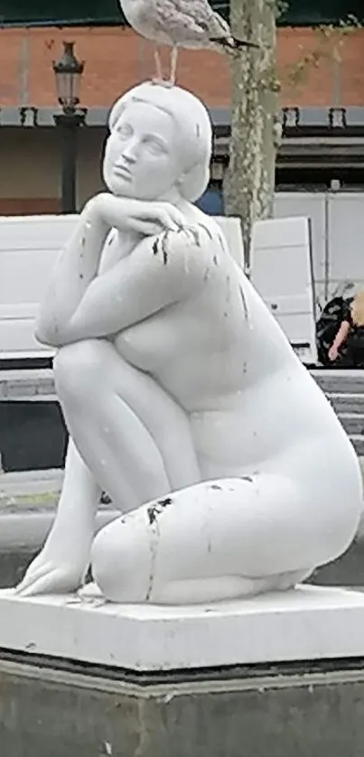 Statue with a seagull perched on top in an urban setting.