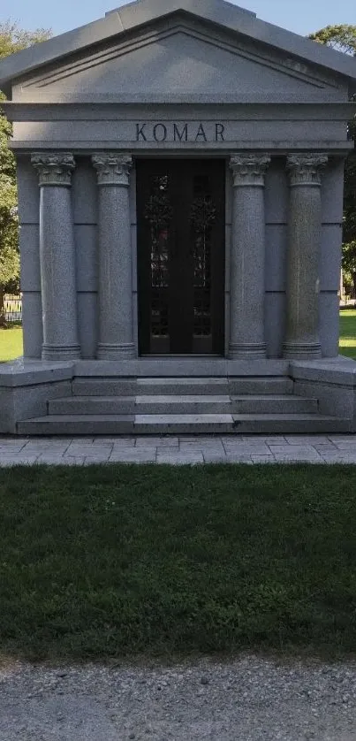 Stone mausoleum amidst lush green landscape, capturing historic charm.