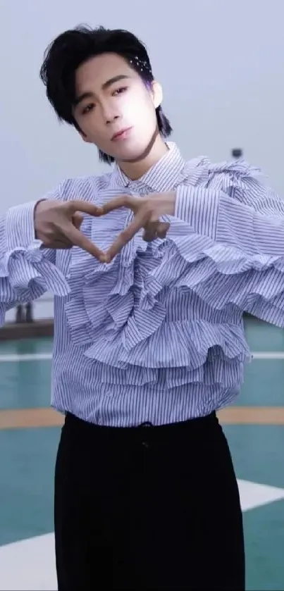 Person in ruffled shirt with heart gesture on helipad.