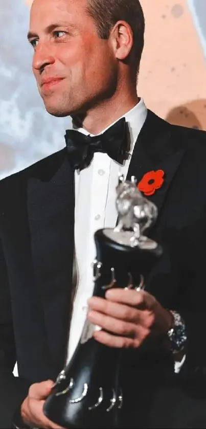 Man in tuxedo holding award with a stylish background.