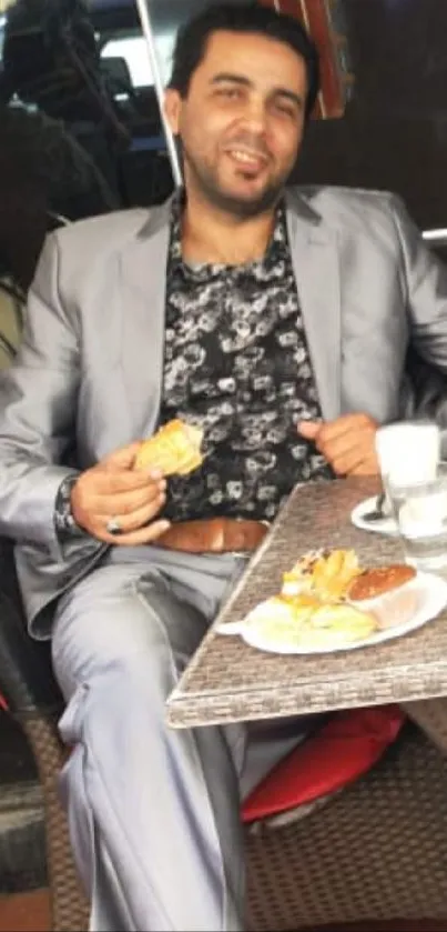 Man in gray suit dining at an outdoor cafe.