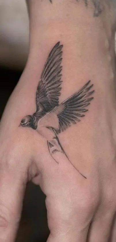 Hand tattoo with swallow design on beige background.